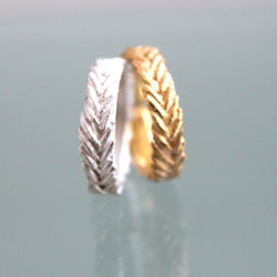 Cumin seeds arranged in a chevron detailed leaf pattern.  Two rings, one in sterling silver and the other in gold. The beauty of nature