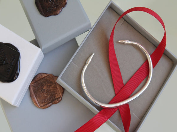 Silver open arrowhead bangle, heavyweight and solid with arrows at the ends . Shown in gift box