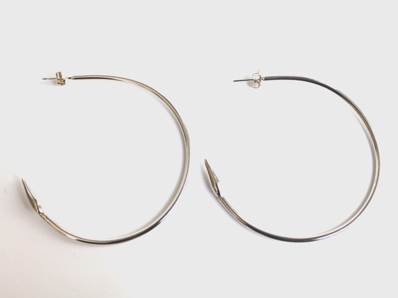 Silver medium hoop earrings with sculpted arrows at the ends
